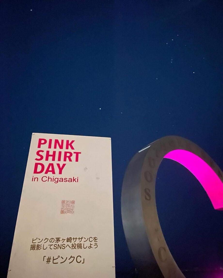 ピンクシャツデーの看板とピンクにライトアップされた茅ヶ崎サザンC